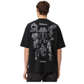 A man viewed from behind wearing a black t-shirt with a large white graphic print of a skeleton and occult symbols, on a white background.