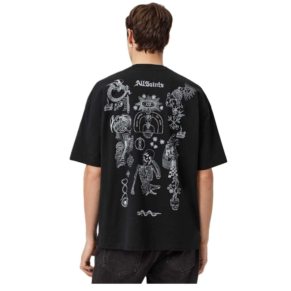 A man viewed from behind wearing a black t-shirt with a large white graphic print of a skeleton and occult symbols, on a white background.