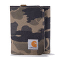 A Carhartt canvas wallet in a brown, beige, and black camouflage pattern, featuring a white Carhartt brand patch on the front flap.
