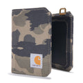 A Carhartt camouflage canvas card holder wallet shown from the front and side, featuring a white Carhartt logo patch on the front and a gold-tone metal loop at the top, set against a plain white background.