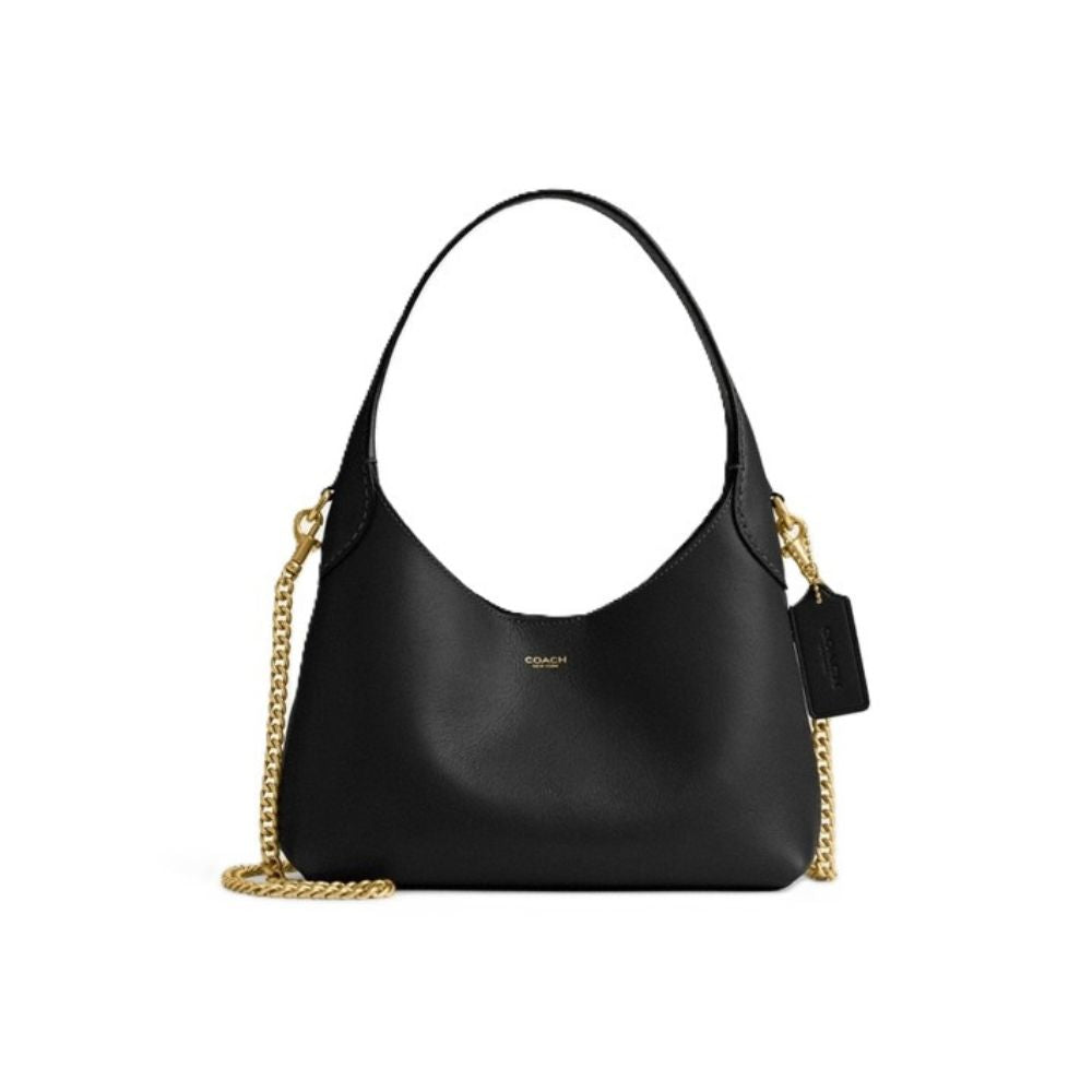 A black leather shoulder bag with a gold chain strap and a small gold Coach logo on the front, shown against a plain white background.