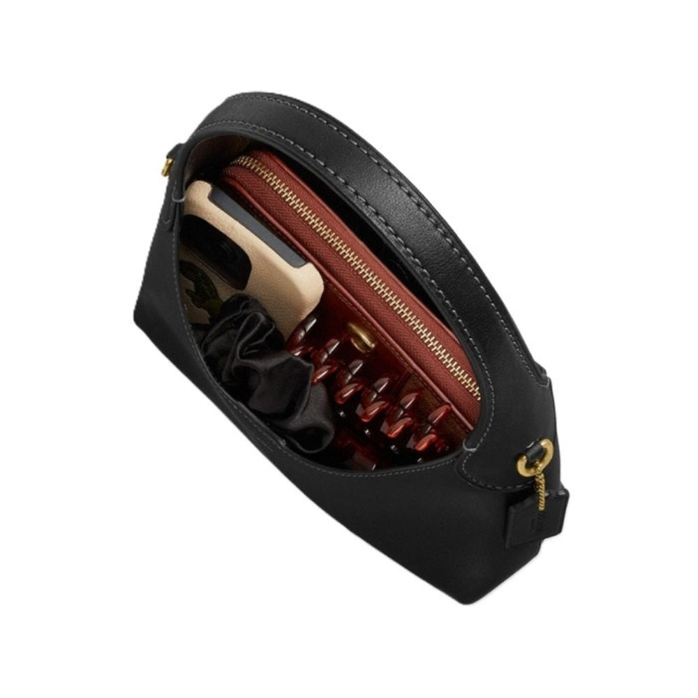 A black leather pouch shown open, revealing a reddish-brown interior with a zipper, a cream cardholder, and dark accessories inside, photographed on a plain white background.