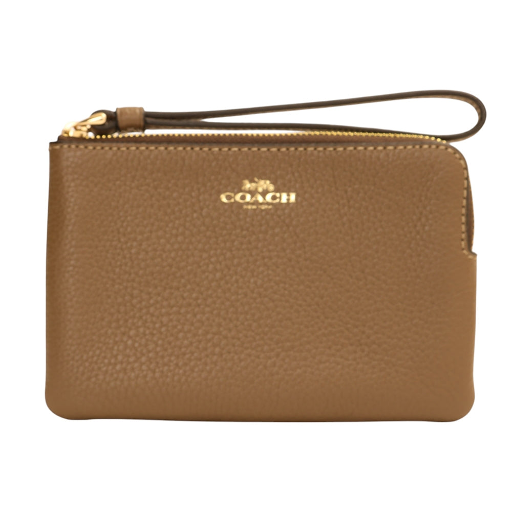 A Coach pebbled leather wristlet pouch in tan brown, featuring a top zipper with gold-tone hardware, a wrist strap, and the gold Coach logo on the front.