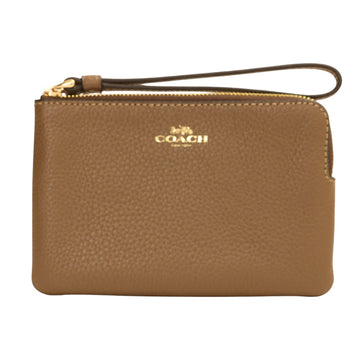 A Coach pebbled leather wristlet pouch in tan brown, featuring a top zipper with gold-tone hardware, a wrist strap, and the gold Coach logo on the front.