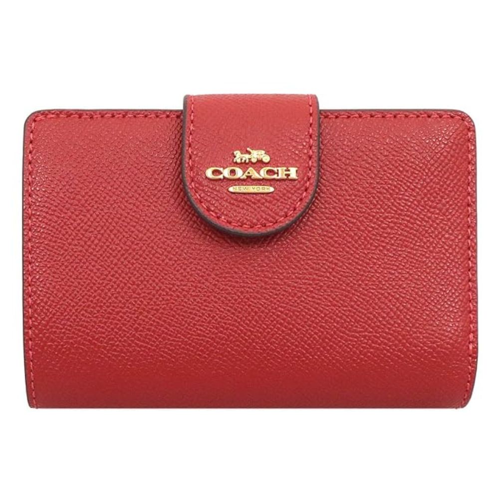 A red pebbled leather Coach wallet with a gold-tone logo on the front flap, shown against a plain white background.