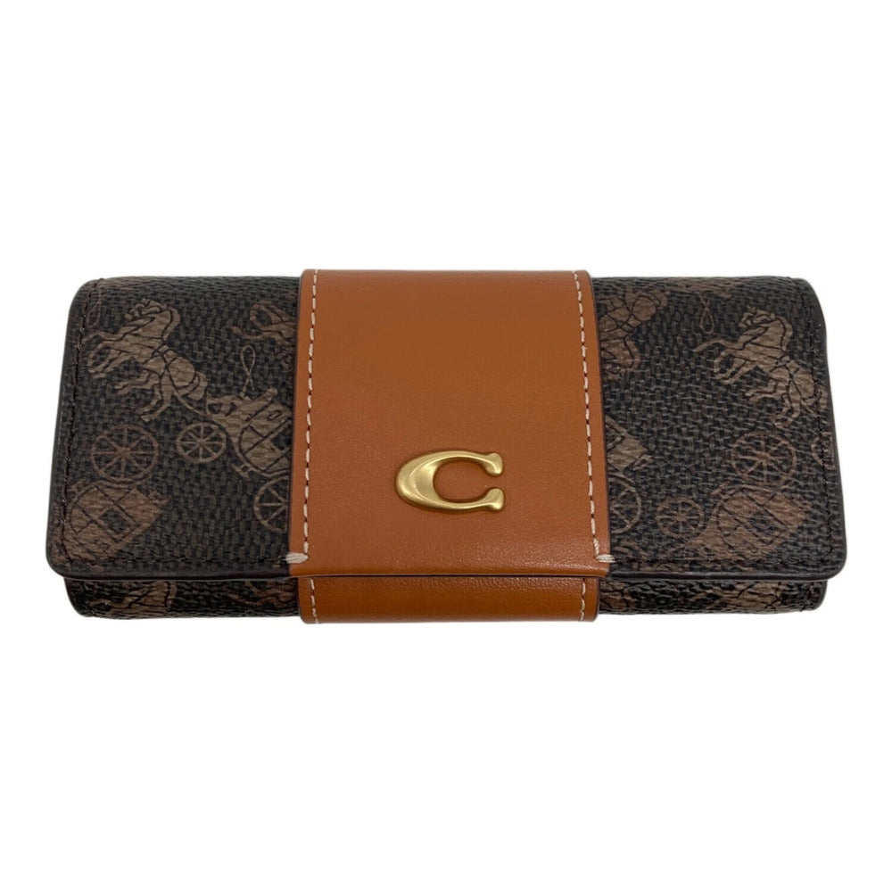 A Coach wallet in the brand's signature brown monogram canvas, featuring a tan leather center band with white contrast stitching and a gold-tone 'C' logo clasp.