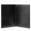A black leather wallet shown open against a white background, displaying its interior card slots, pocket, and smooth leather texture. The brand name 'COACH' is subtly embossed on the lower left of the left panel.