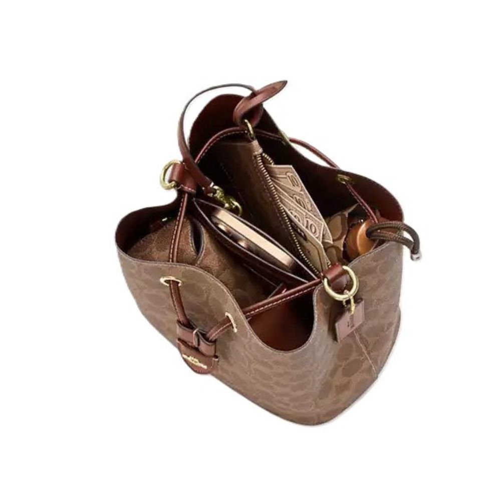 A brown textured leather handbag shown open from an overhead angle, revealing its interior compartments, zipper, and gold-tone hardware, set against a plain white background.