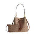 A brown and beige patterned Coach handbag with a matching zip pouch, displayed on a clean white background.