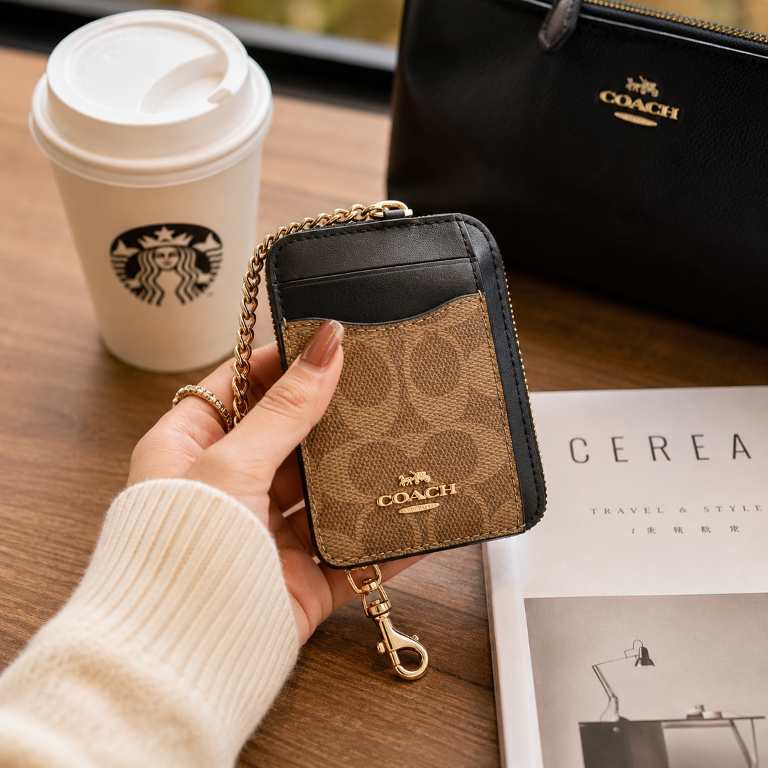 A Coach mini card holder wallet in signature canvas with black leather trim and a gold-tone chain strap, shown on a plain white background.