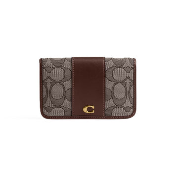 A Coach card holder wallet featuring the brand's signature monogram canvas in brown and beige, with a solid dark brown leather center panel and a gold-tone 'C' logo on the front.