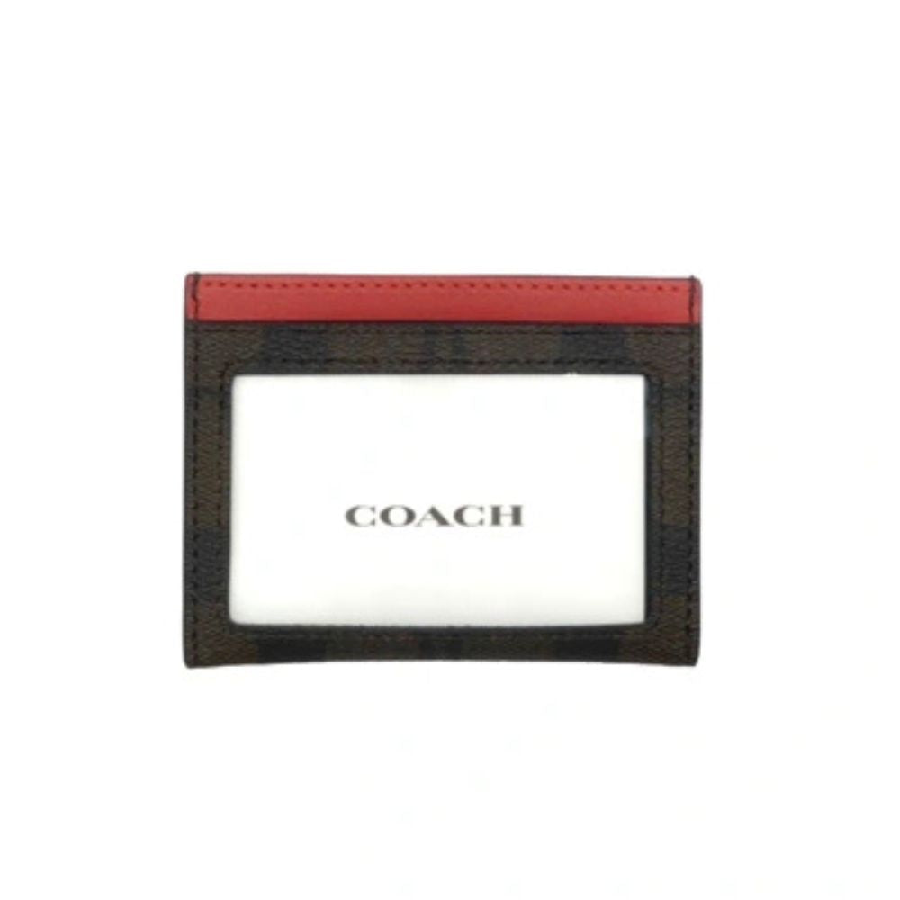 A Coach card holder featuring a dark brown and black plaid pattern with a red leather top border and a white center insert displaying the Coach logo.