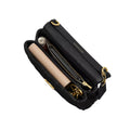A black leather shoulder bag shown open, revealing a beige zippered pouch inside, gold-tone hardware, and a small round embellished accessory. The brand name 'MICHAEL MALCOLM' is subtly printed in gold on the black leather flap.