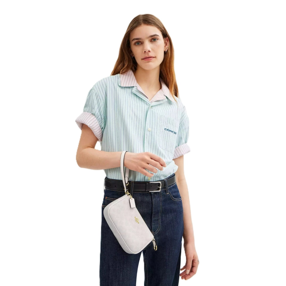 A model wearing a light blue and white striped short-sleeve button-up shirt, dark blue jeans, and a light gray crossbody bag, photographed against a solid white background.