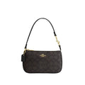 Black Coach handbag with gold accents on a light gray background