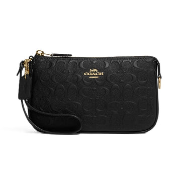 A black Coach crossbody bag with an embossed signature C pattern, gold-tone hardware, and a wristlet strap, shown against a plain white background.