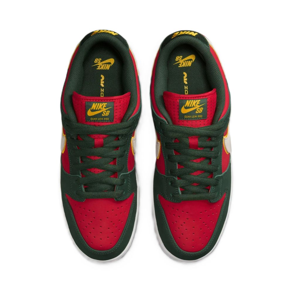 A pair of Nike SB Dunk Low sneakers shown from a top-down view. The shoes feature a dark forest green suede upper with vibrant red overlays, yellow and white accents on the tongue, side, and heel, and a white rubber sole.