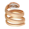 A rose gold snake-style bangle watch with an integrated oval watch face, coiled to display its textured, ribbed band and clear crystal back.