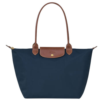 Navy blue tote bag with brown leather handle and trim on a white background