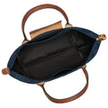 An overhead view of an open navy blue handbag with brown leather handles, a black interior lining, and gold-tone hardware on a white background.