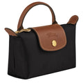 Black handbag with brown leather accents on a white background