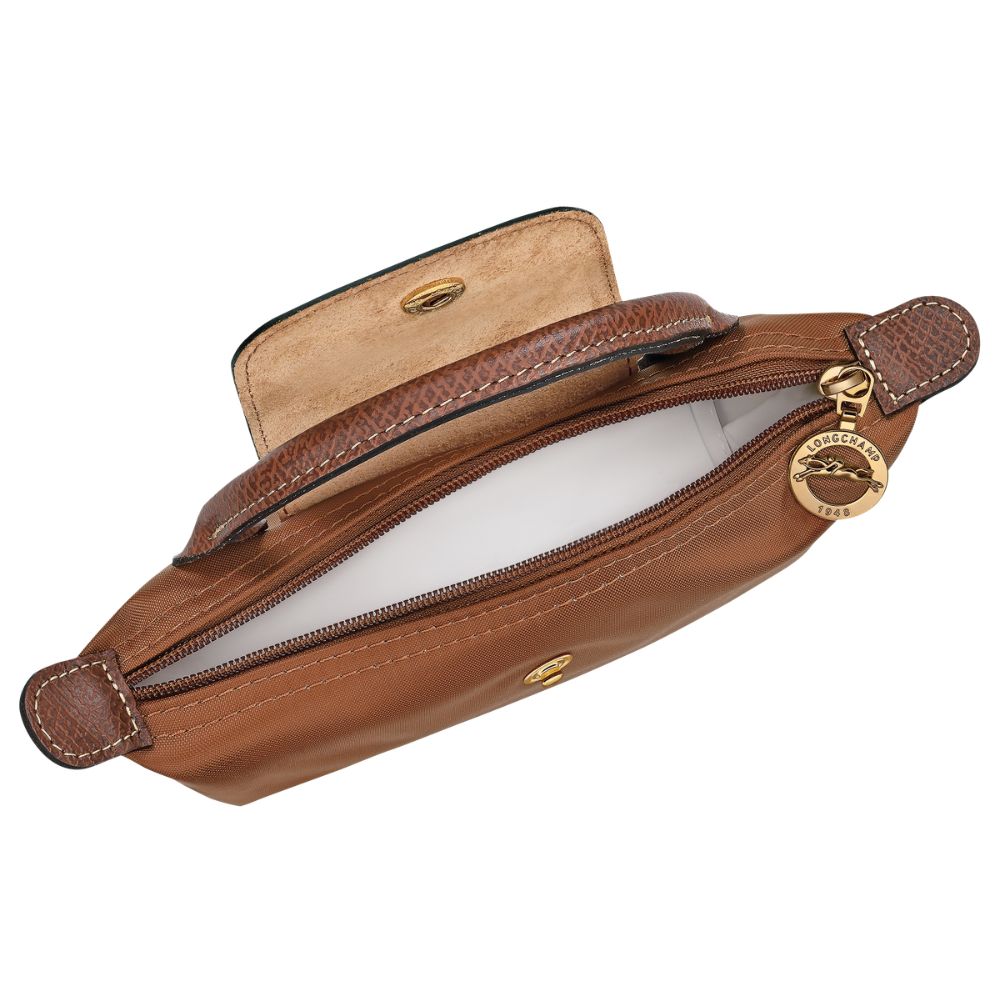 A brown leather pouch shown open, revealing a light beige interior lining and a gold-tone metal zipper pull with a circular brand charm.
