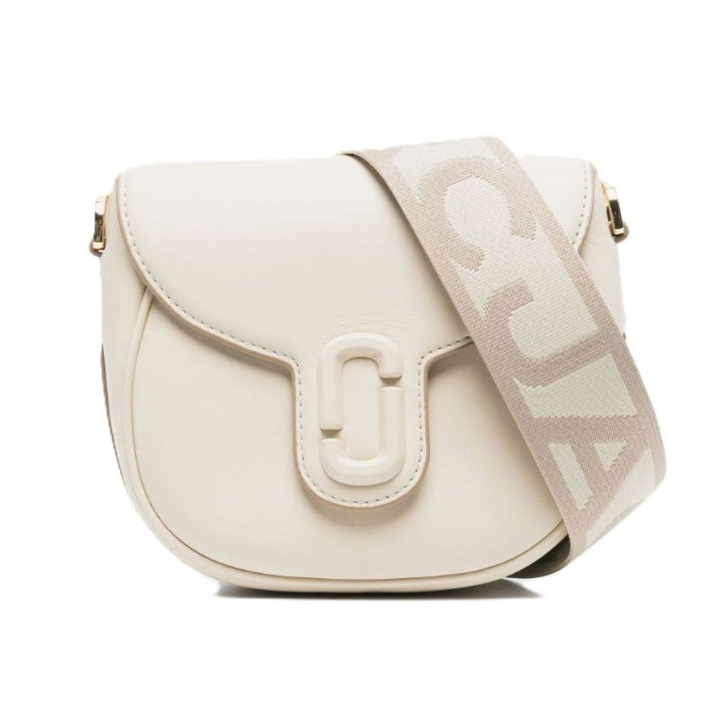 An off-white leather shoulder bag with a flap closure, a large decorative front clasp, and a wide beige woven strap featuring large white lettering, shown on a plain white background.