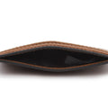 Close-up of the interior of a brown textured leather card holder or wallet, showing tan stitching, a black inner lining, and a black edge trim on a white background.