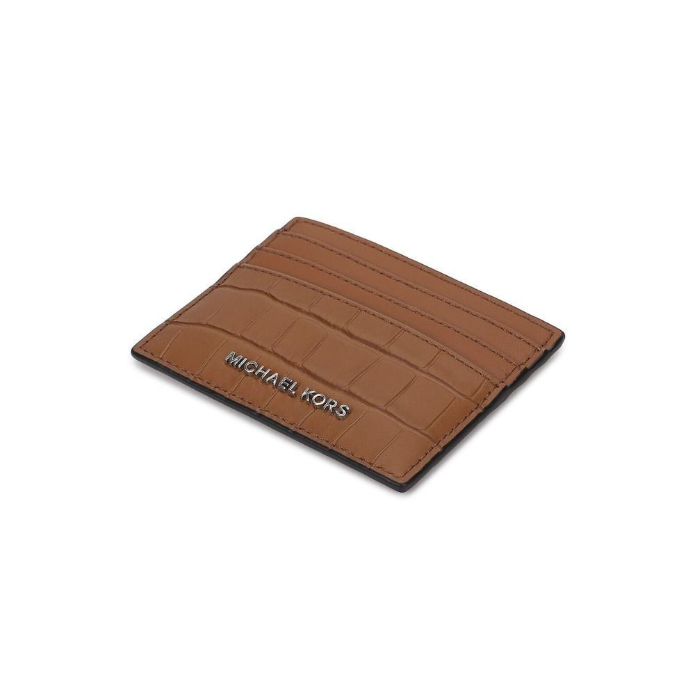 A brown Michael Kors card holder with an embossed crocodile pattern and silver-tone logo lettering, shown on a plain white background.
