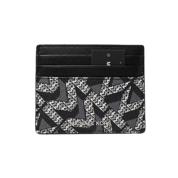Michael Kors card holder wallet in black and gray monogram canvas with a black leather trim and a black brand tag, shown on a plain white background.