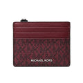Michael Kors card holder in burgundy leather with a monogram pattern and silver-tone logo lettering, shown on a plain white background.