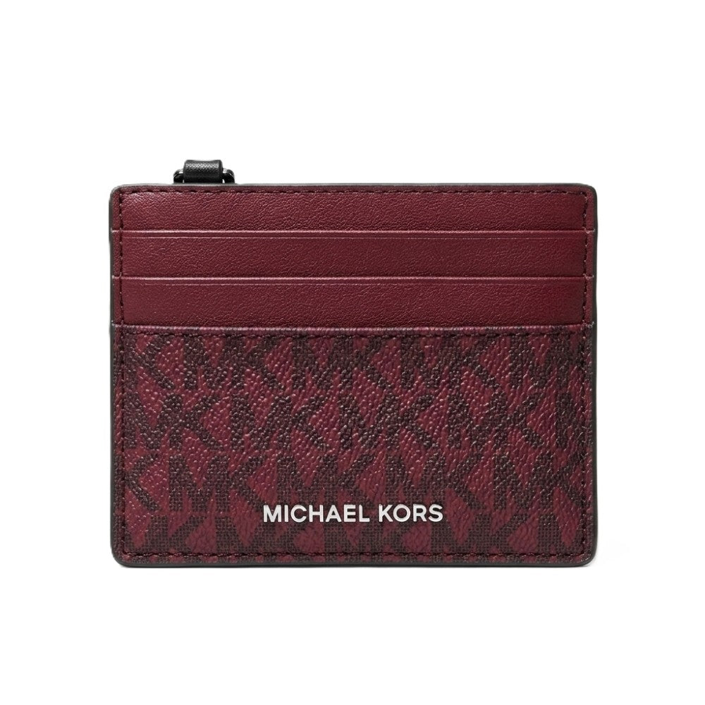 Michael Kors card holder in burgundy leather with a monogram pattern and silver-tone logo lettering, shown on a plain white background.