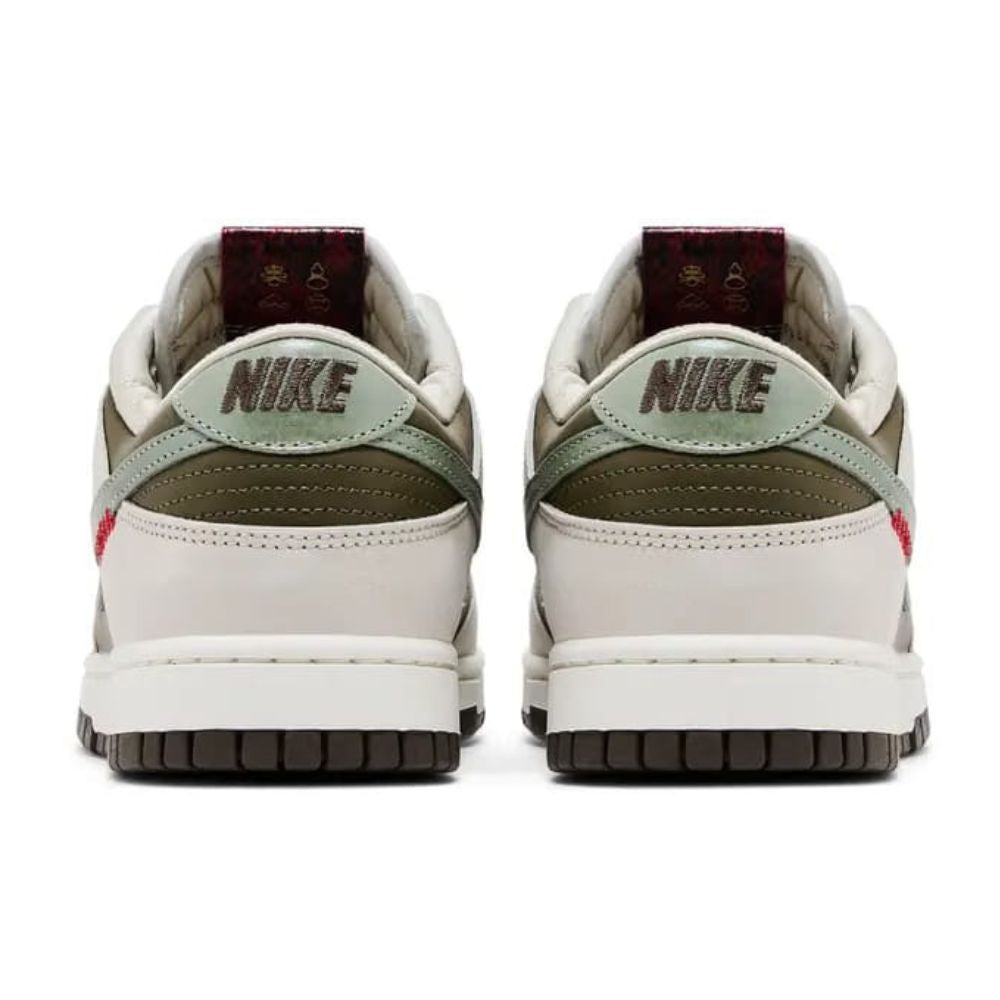 A pair of Nike Dunk Low sneakers shown from the back, featuring off-white leather overlays, olive green suede panels, a light sage green heel tab, and a dark brown outsole.