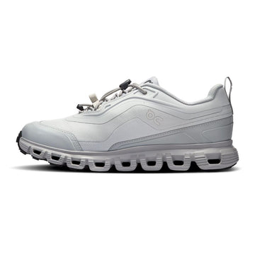 A light gray and white low-top athletic sneaker shown from the side profile on a clean white background. The shoe features a textured mesh upper, a chunky sculpted sole with circular cutouts, and a small embossed logo on the side.
