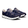 Pair of navy running shoes with white soles on a white background