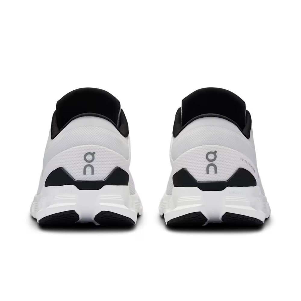 A pair of white and black running shoes shown from the back, featuring a white mesh upper, black collar lining, and a black and white chunky sole with a gray 'on' logo.