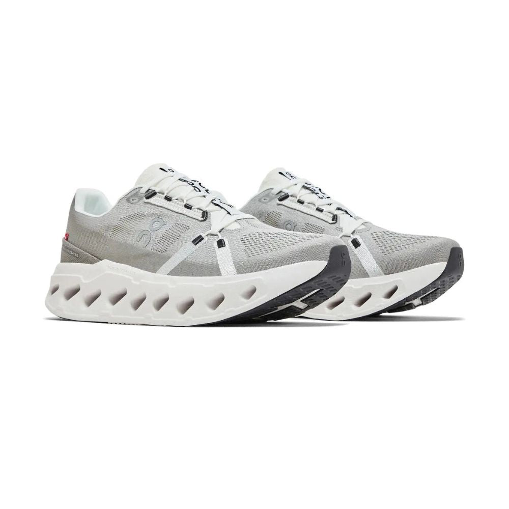 A light gray and white athletic sneaker shown from the side against a plain white background. The shoe features a gray mesh and textile upper with a thick, sculpted white sole featuring multiple cutouts.