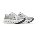 A pair of light gray and white athletic sneakers with a chunky, sculpted white sole featuring circular cutouts, set against a plain white background.