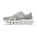 A light gray and white athletic sneaker shown from the side against a plain white background. The shoe features a gray mesh and textile upper with a thick, sculpted white sole featuring multiple cutouts.