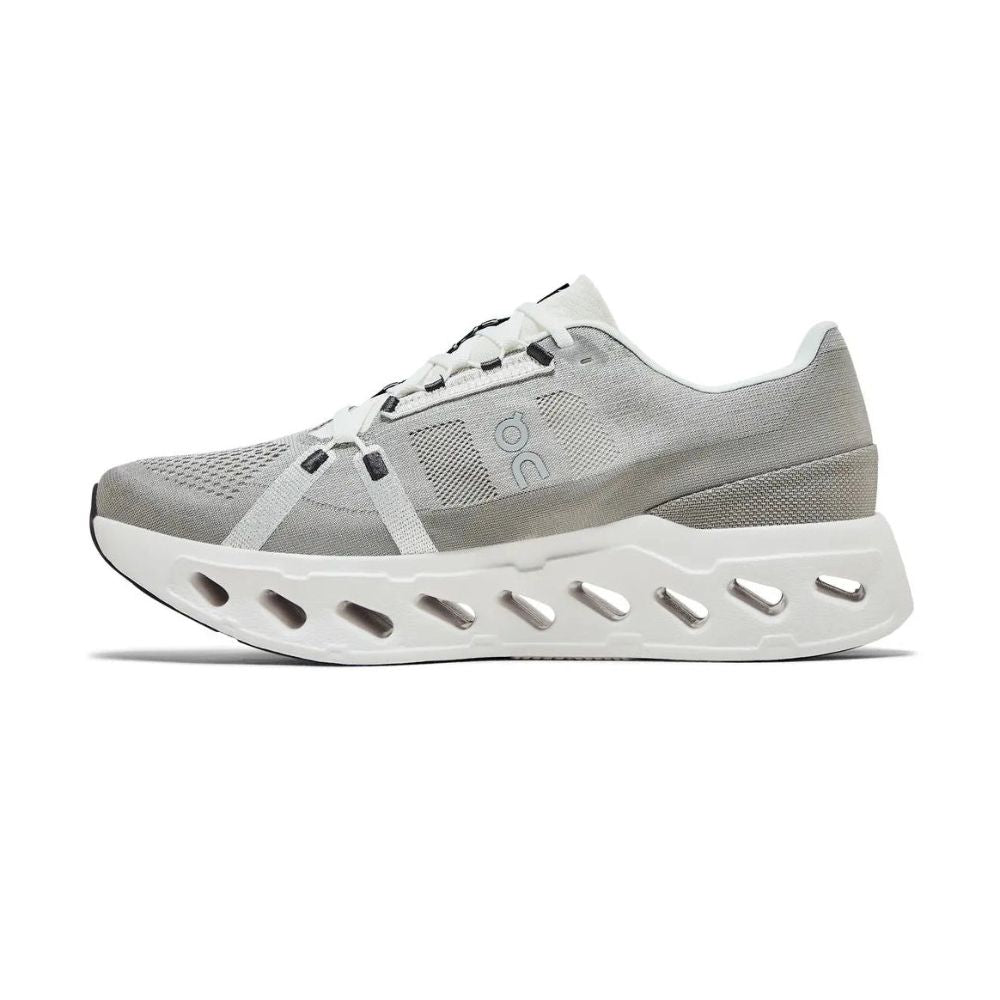 A light gray and white athletic sneaker shown from the side against a plain white background. The shoe features a gray mesh and textile upper with a thick, sculpted white sole featuring multiple cutouts.