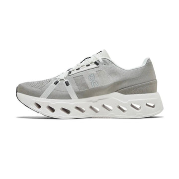 A light gray and white athletic sneaker shown from the side against a plain white background. The shoe features a gray mesh and textile upper with a thick, sculpted white sole featuring multiple cutouts.
