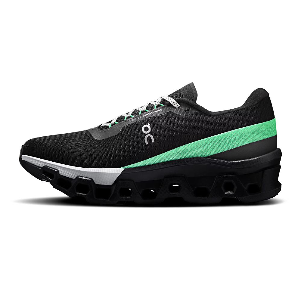 A black On running shoe with a bright green side stripe, white laces, and a chunky black sole with cutout details, shown from a side profile on a white background.