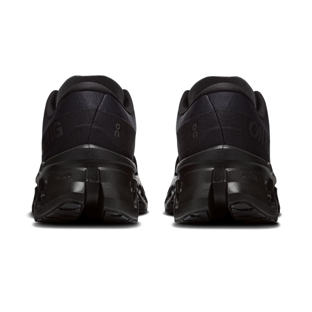 A pair of black On running shoes shown from the rear, featuring a chunky black sole and subtle tonal branding on a clean white background.