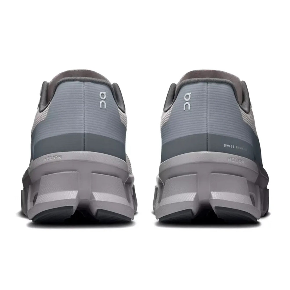 A pair of gray On running shoes shown from the rear, featuring the On logo on the heel and a chunky gray and black sole, set against a plain white background.