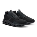 A pair of On Cloudrunner sneakers in an all-black colorway, featuring a textured mesh upper, integrated laces, and a chunky cushioned sole with visible air pockets, set against a plain white background.