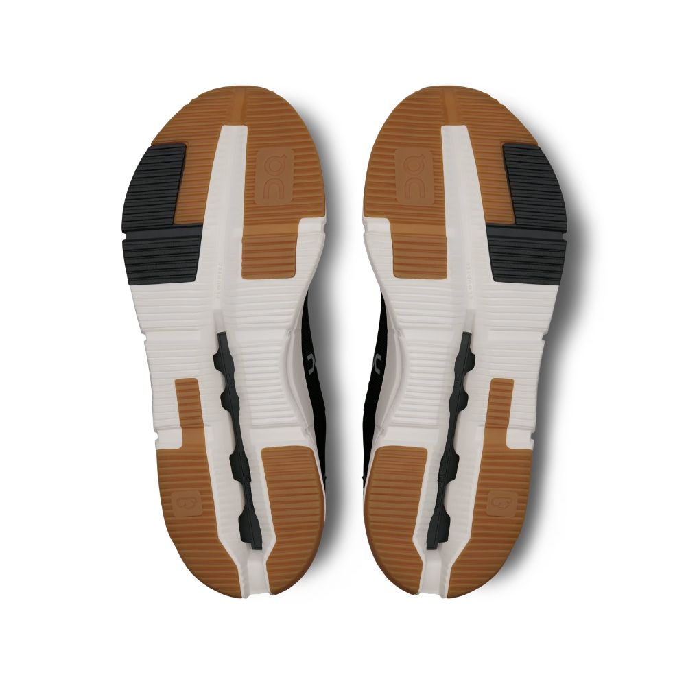 Top-down view of a pair of athletic shoes showing the textured brown, white, and black outsoles against a white background.