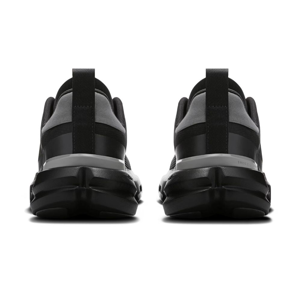 A pair of black and gray athletic sneakers shown from the rear, featuring chunky black soles and pull tabs, set against a plain white background.