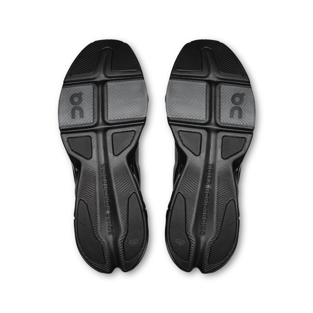 Black athletic shoe soles with 'On' branding on a white background