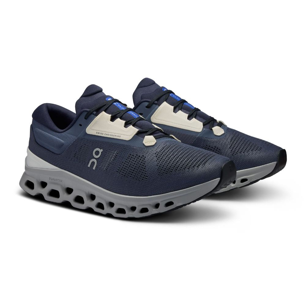 A navy blue running shoe with a white and gray sole, featuring the On logo on the side, shown against a plain white background.