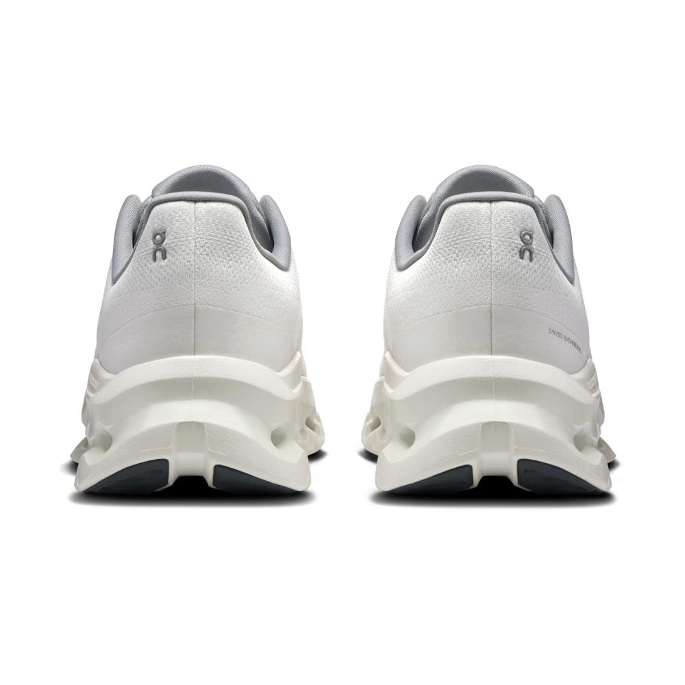 A pair of white and gray athletic sneakers shown from the back, featuring chunky sculpted midsoles and a small gray logo on the heel.